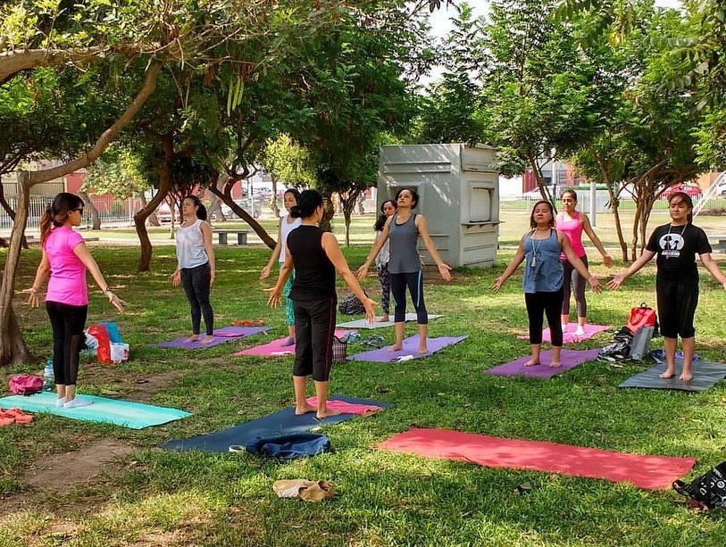 Sandra Rovegno dictando yoga en un parque.