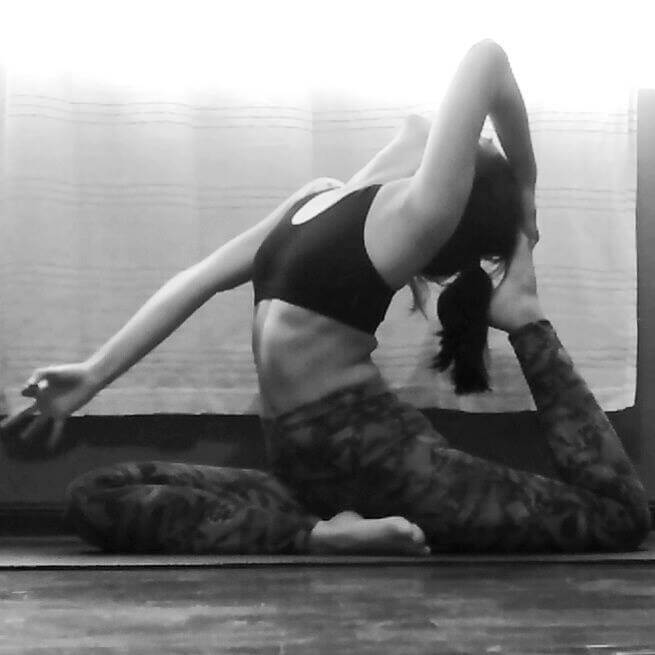 Sandra Rovegno haciendo una postura de yoga donde estira su cuerpo.